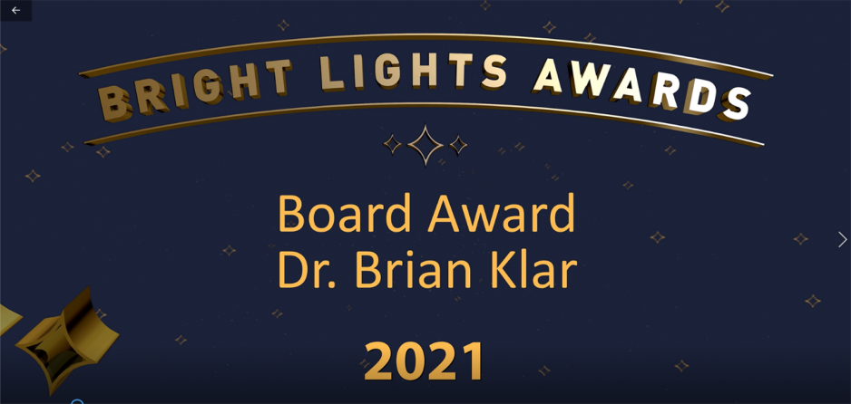 Screenshot of opening of 2021 board award winner video. Logo at top with Board Award, Dr. Brian Klar 2021 below. Background is navy blue with gold stars.